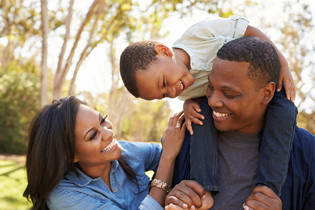 Father and daughter sitting on a grey sofa using an iPad to activate their online Child Trust Fund account