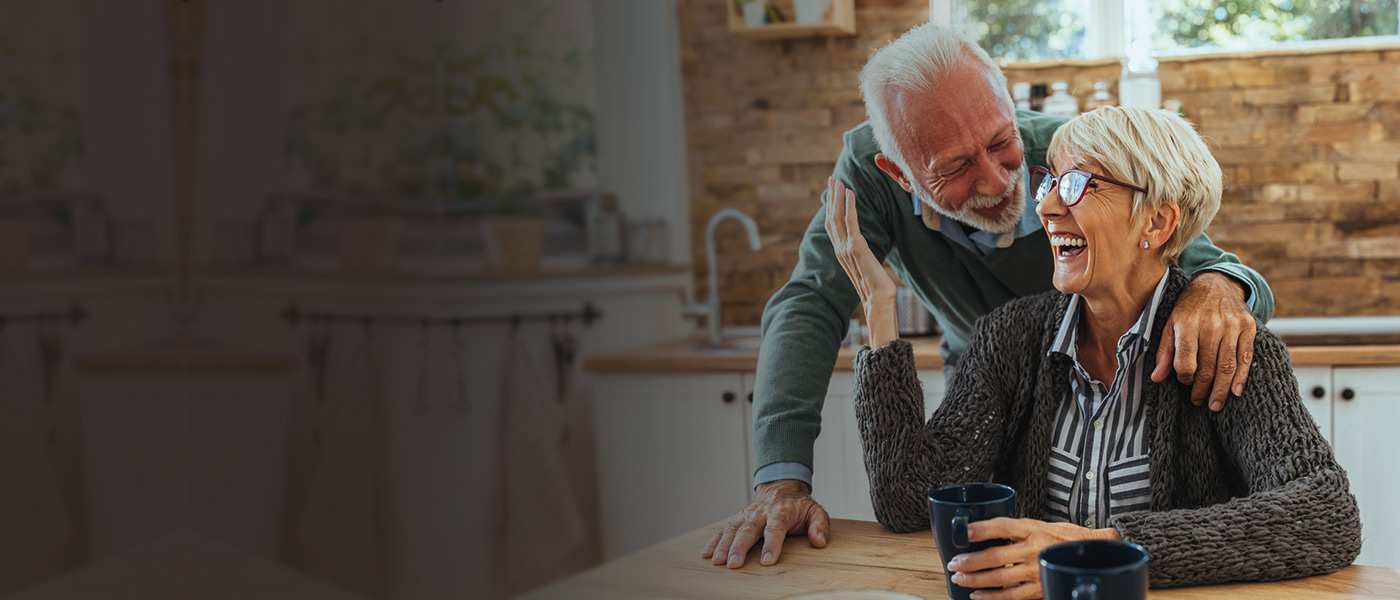 Happy couple in the kitchen who have a With-Profits Plan